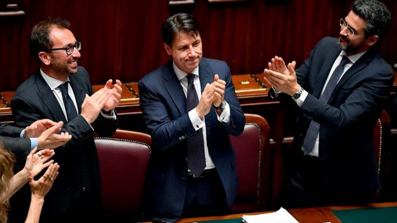 Justice Minister Alfonso Bonafede, left, and Minister for Parliament Relations Riccardo Fraccaro, right, applaude Premier Giuseppe Conte.