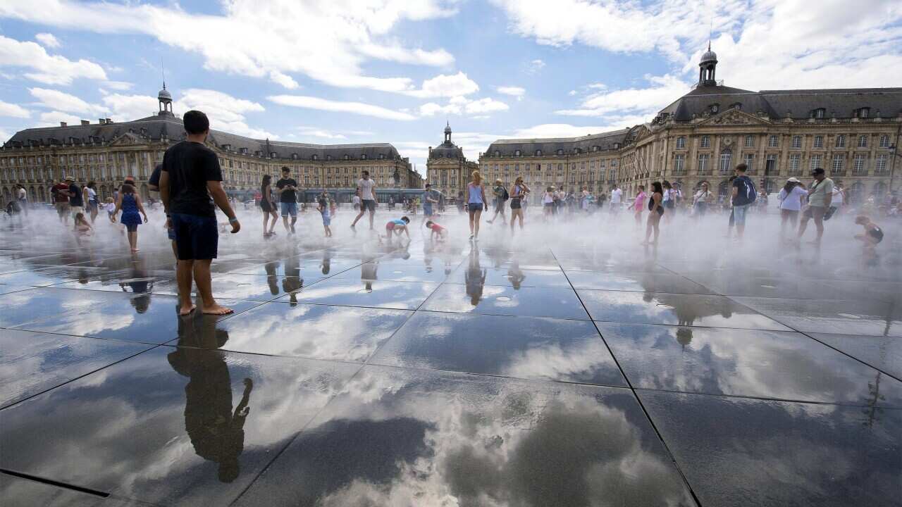 People refresh themselves in the Water Mirror fountain in the centre of Bordeaux, France.