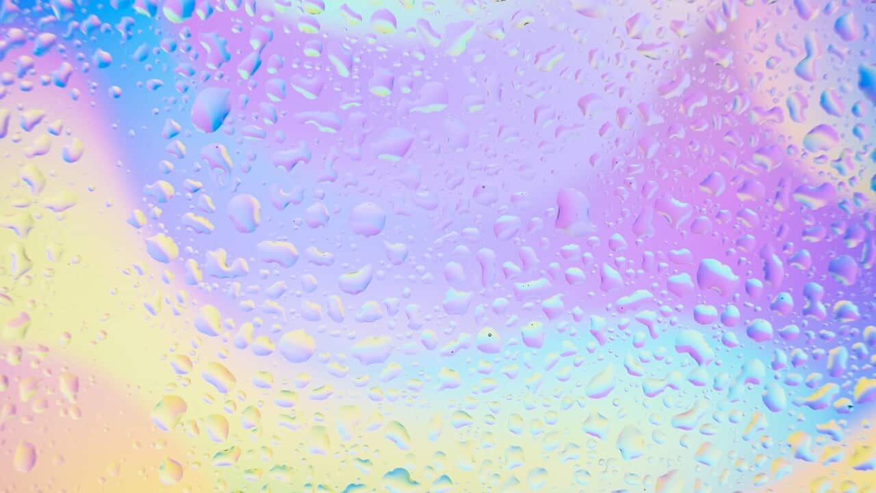 Waterdrops on window glass with colourful background .