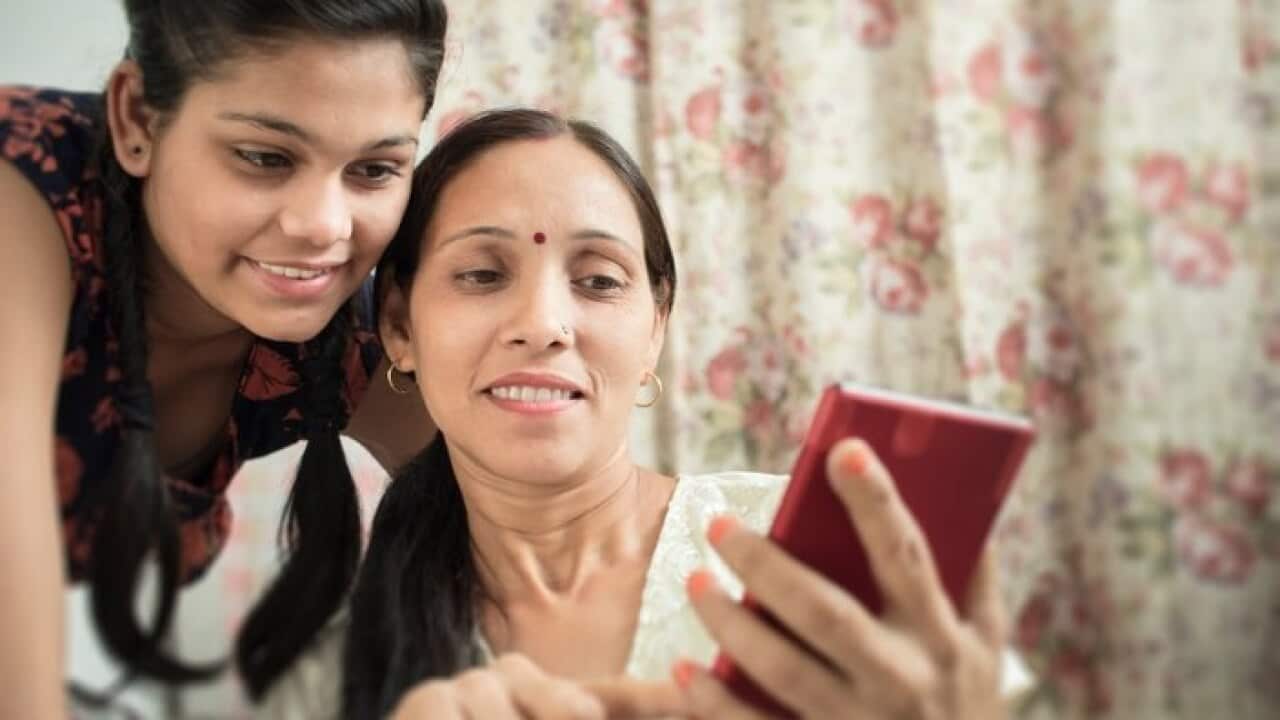 Mother and daughter using phone together