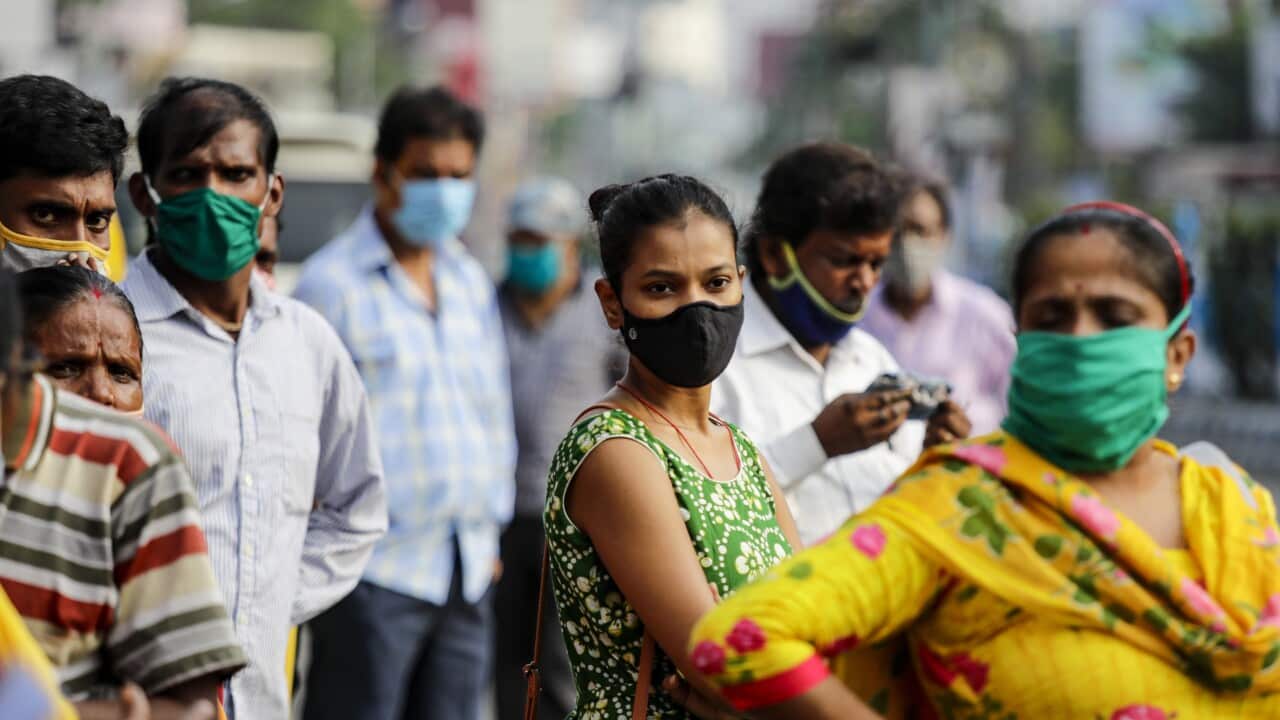 Commuters wait for a bus in Kolkata, India