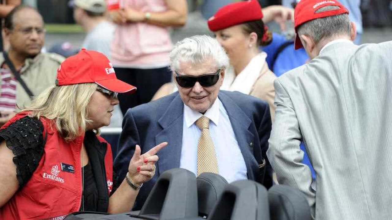Trainer Bart Cummings makes his way into a car on St. Kilda Rd after the Melbourne Cup Parade in Melbourne