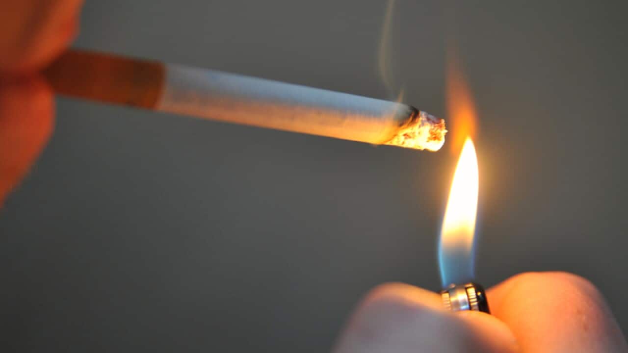 A man seen lighting a cigarette in Sydney