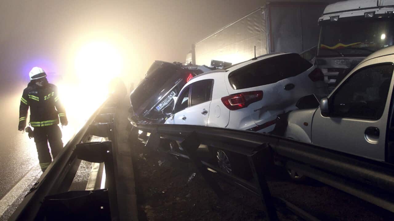 A fireman walks past a pileup on a motorway in Senozece, Slovenia