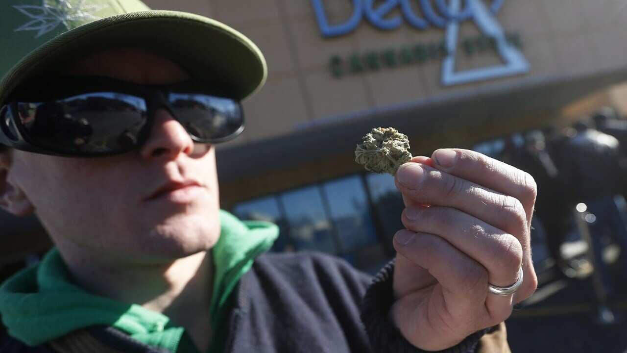 Steven Stairs, Canadian cannabis activist who has advocated for legaliation for years, checks his first legal marijuana outside a cannabis store.