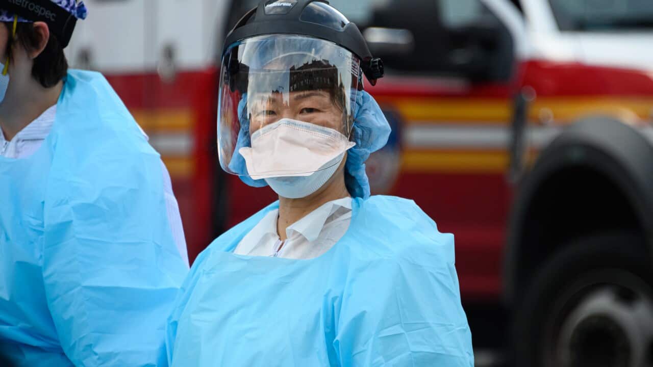 Medical workers walk outside the Elmhurst Hospital Center Emergency Room during the coronavirus pandemic on 20 April, 2020 in New York City.