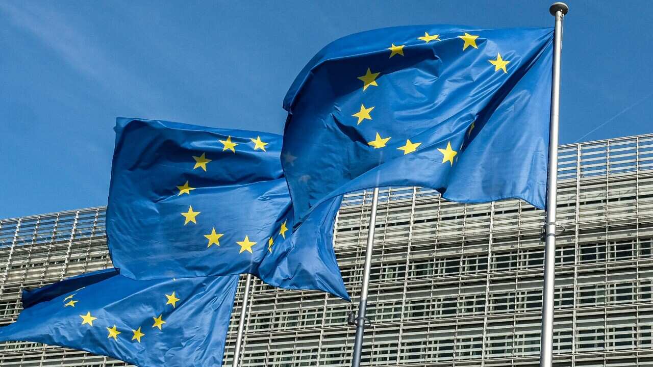 European union flags wave in front of the Berlaymont building headquarters in Brussels