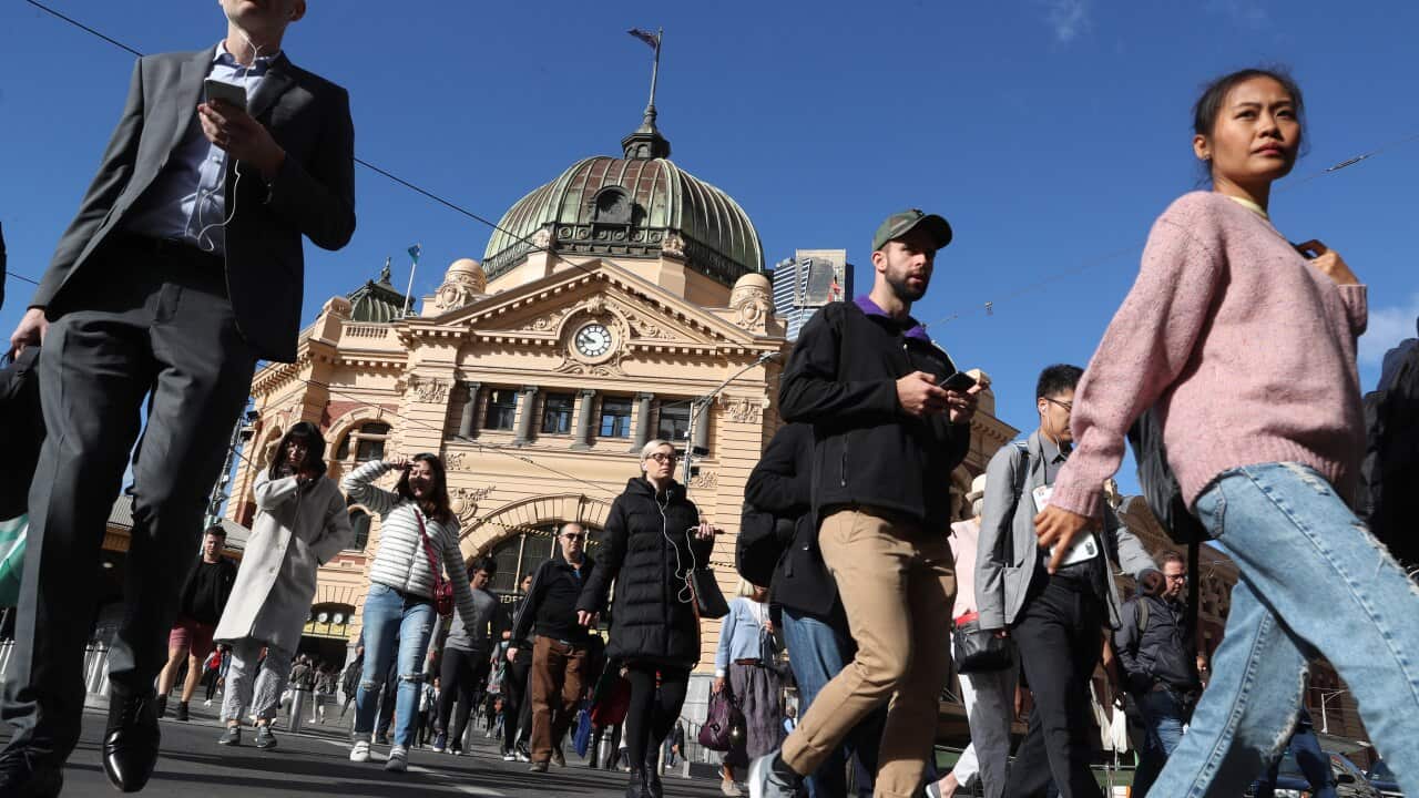 Pedestrians cross the intersection in front of Flinders Street Station in Melbourne, March, 2019.