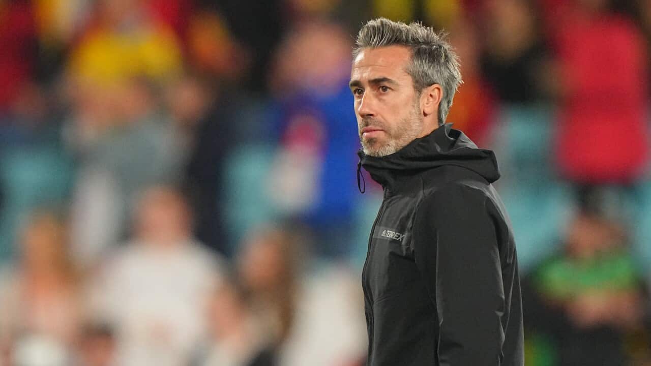 A man in a black tracksuit in a stadium