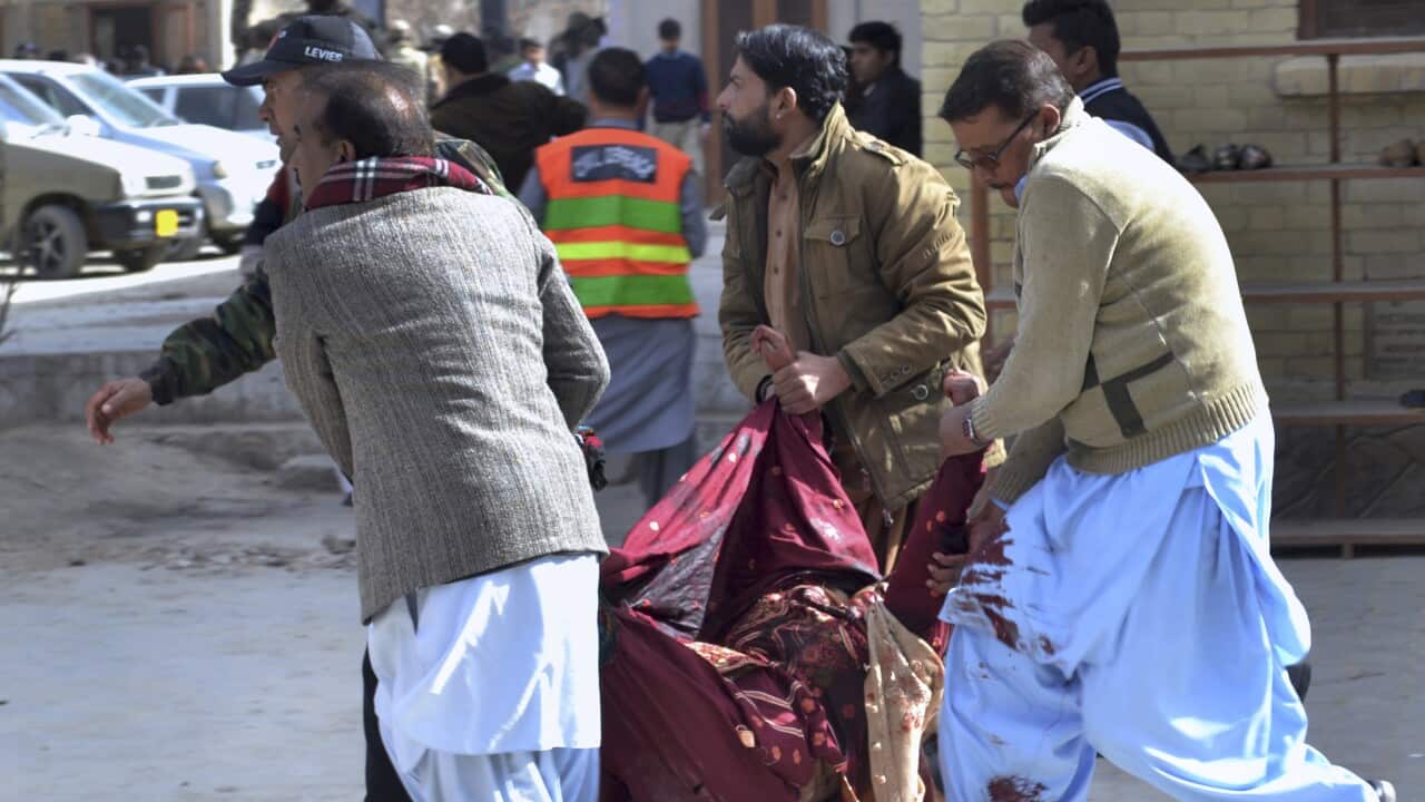 A paramilitary soldier and volunteers rescue an injured women following a suicide attack on a church in Quetta.