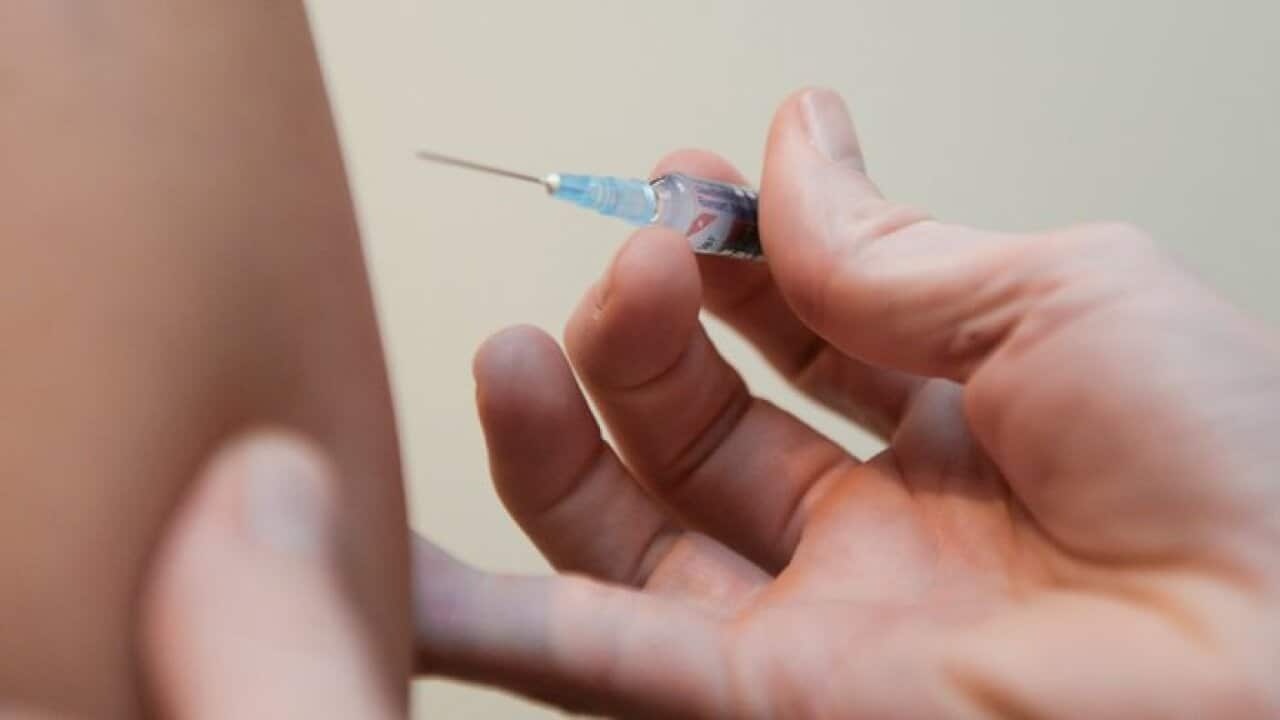 A doctor injects a vaccine at a clinic in Canberra