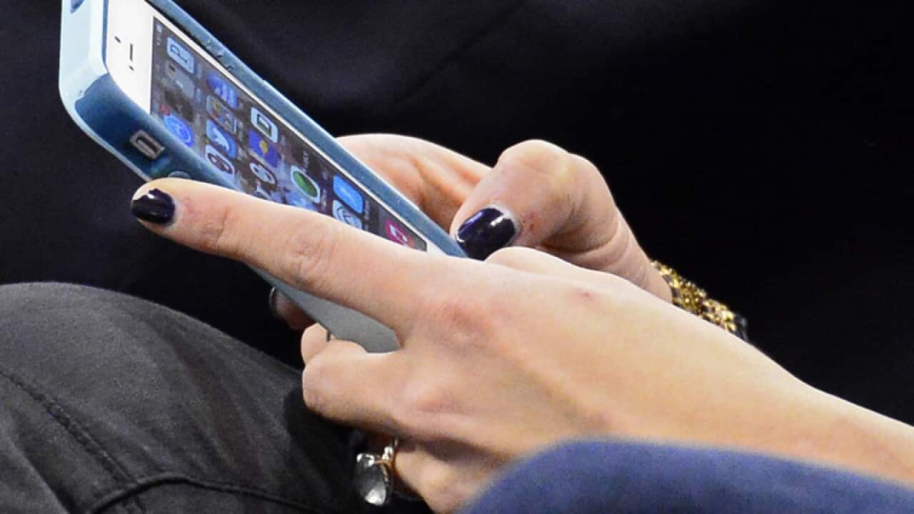 A person uses their iPhone