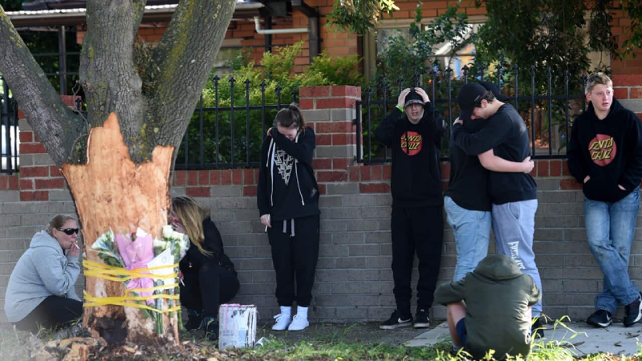 Mourners lay flowers at the scene of a fatal car crash in Melbourne