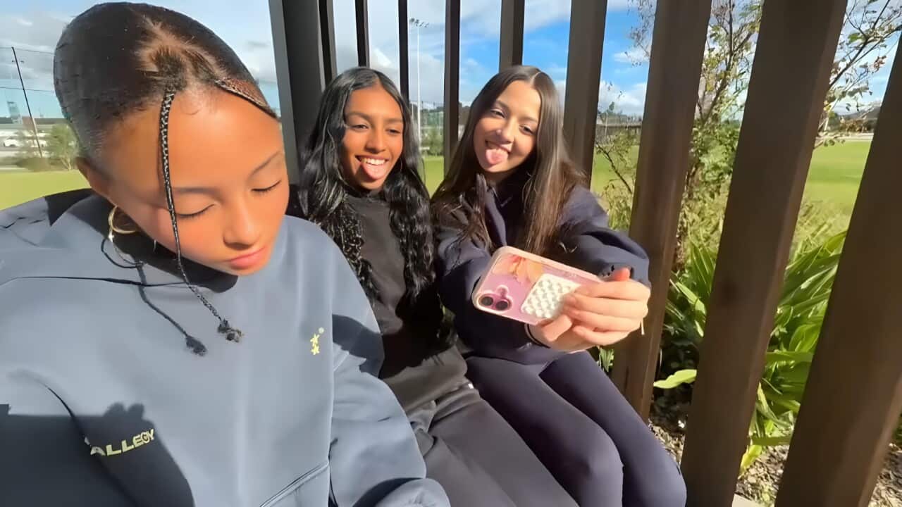 Ela (centre) and her friends enjoying social media (AP).jpg