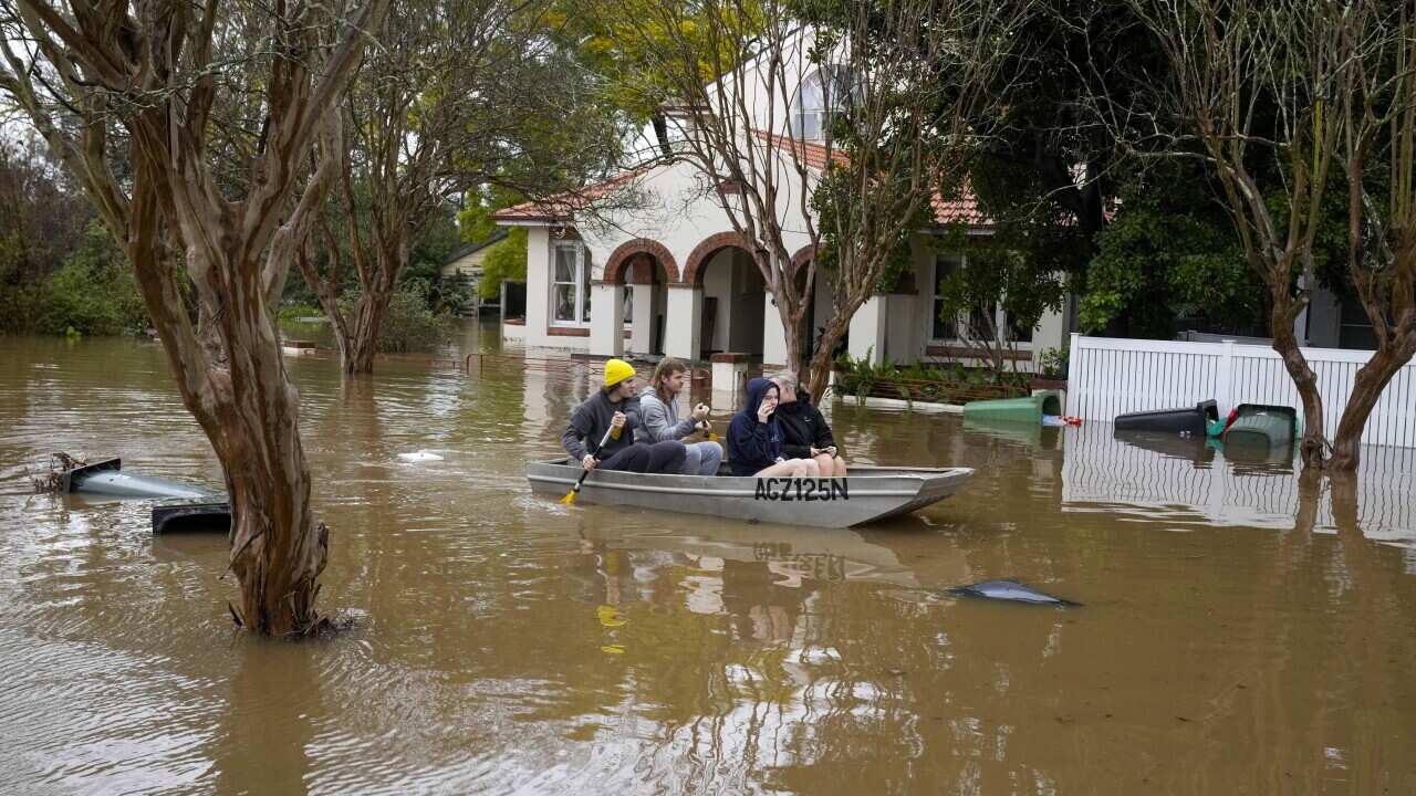 People in a boat on a flooded street
