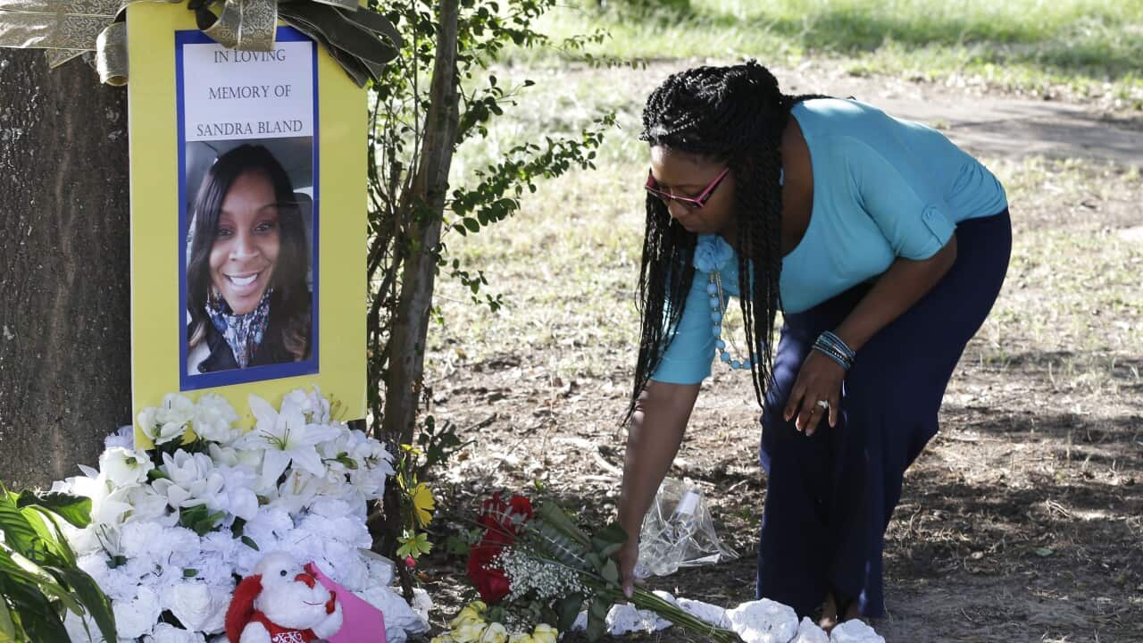 Jeanette Williams places a bouquet of roses at a memorial for Sandra Bland (AP Photo/Pat Sullivan)