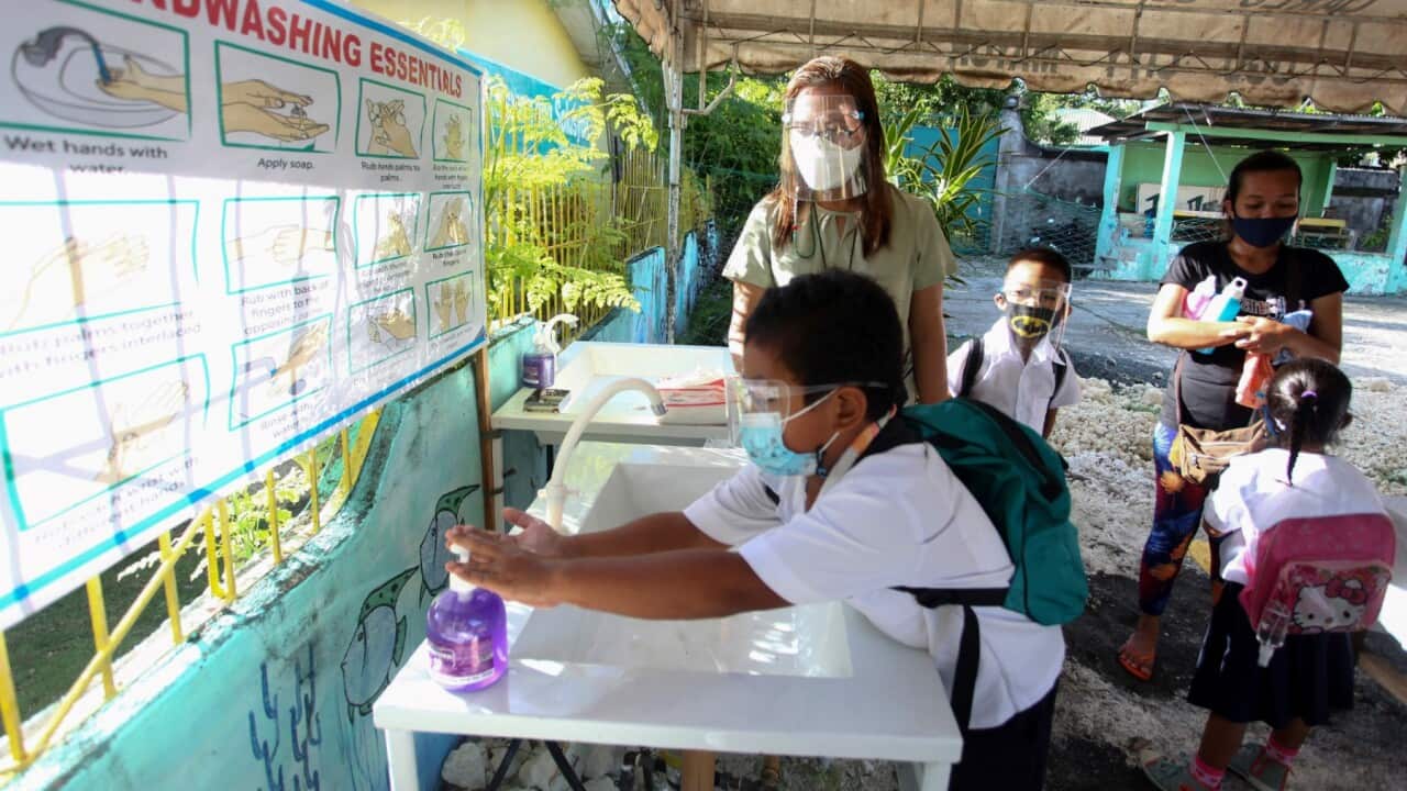 File Photo: A teacher supervises students washing their hands before entering a classroom at Siocon Elementary School for the face-to-face classes in the town of Bogo in Cebu province on November 15, 2021.