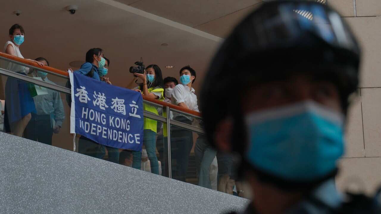 A police officer stands guard as protesters gather at a shopping mall during a pro-democracy protest against Beijing's national security law in Hong Kong.