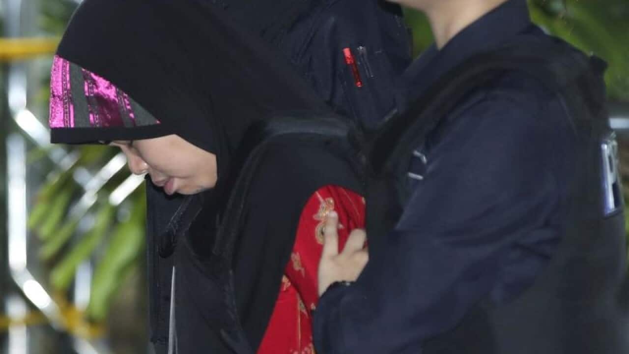 Indonesian Siti Aisya is escorted by police.