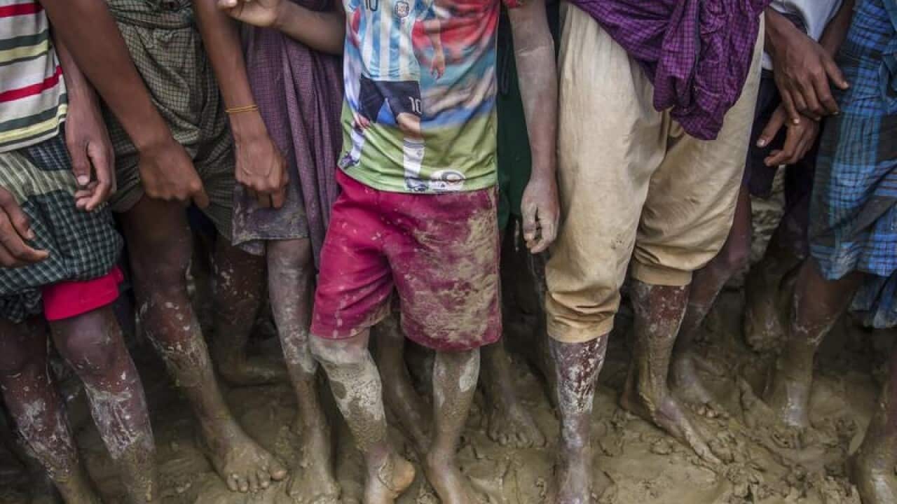 Rohingya Muslims wait to receive handouts