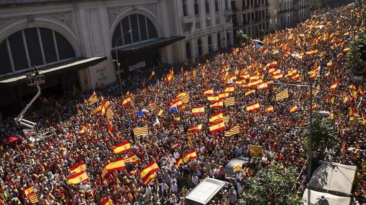People with Spanish and Catalan flags gather during a rally for unity in downtown Barcelona. (AAP)
