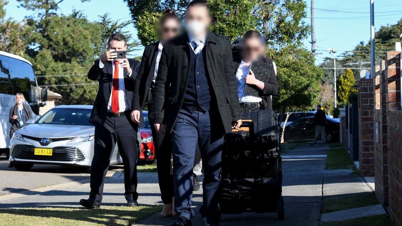 : Federal agents are seen leaving the home of NSW Labor MP Shaoquett Moselmane in Rockdale, Sydney .