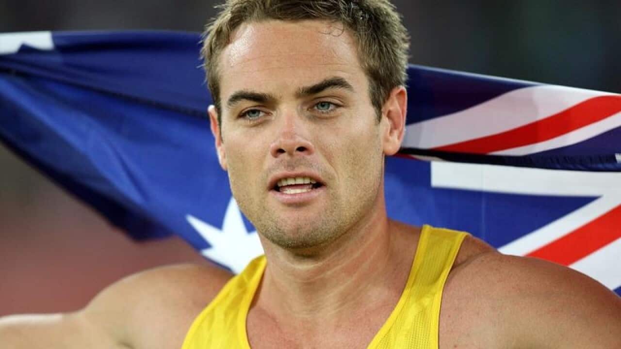 Jarrod Bannister celebrates his medal win holding an Australian flag.