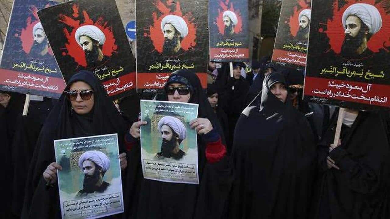 Iranian demonstrators hold posters of Sheikh Nimr al-Nimr, a prominent opposition Saudi Shiite cleric, during a protest denouncing his execution, in front of the Saudi Embassy, in Tehran, Sunday, Jan. 3, 2016. (AAP)