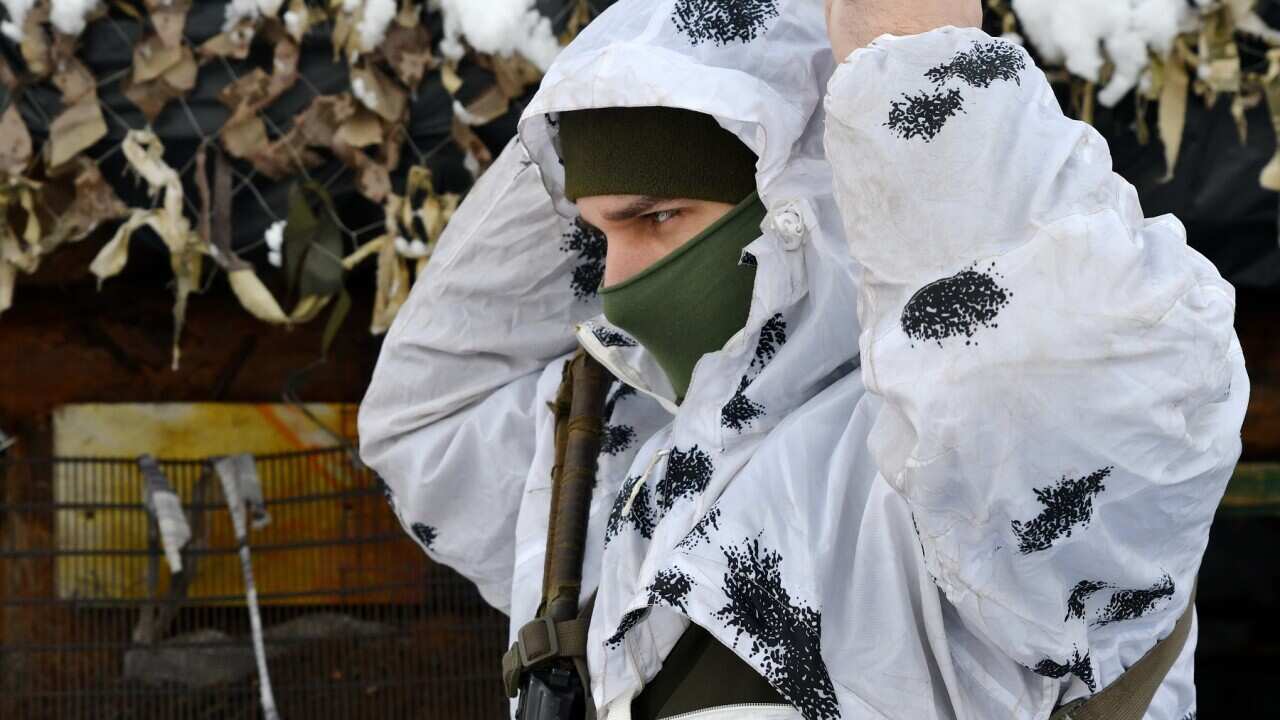 A Ukrainian soldier dons winter camouflage gear on the eastern border with Russia