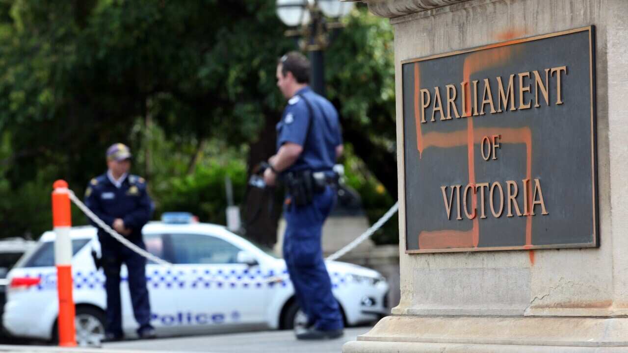 Police inspect graffiti on the front of the Victorian State Parliament (AAP)