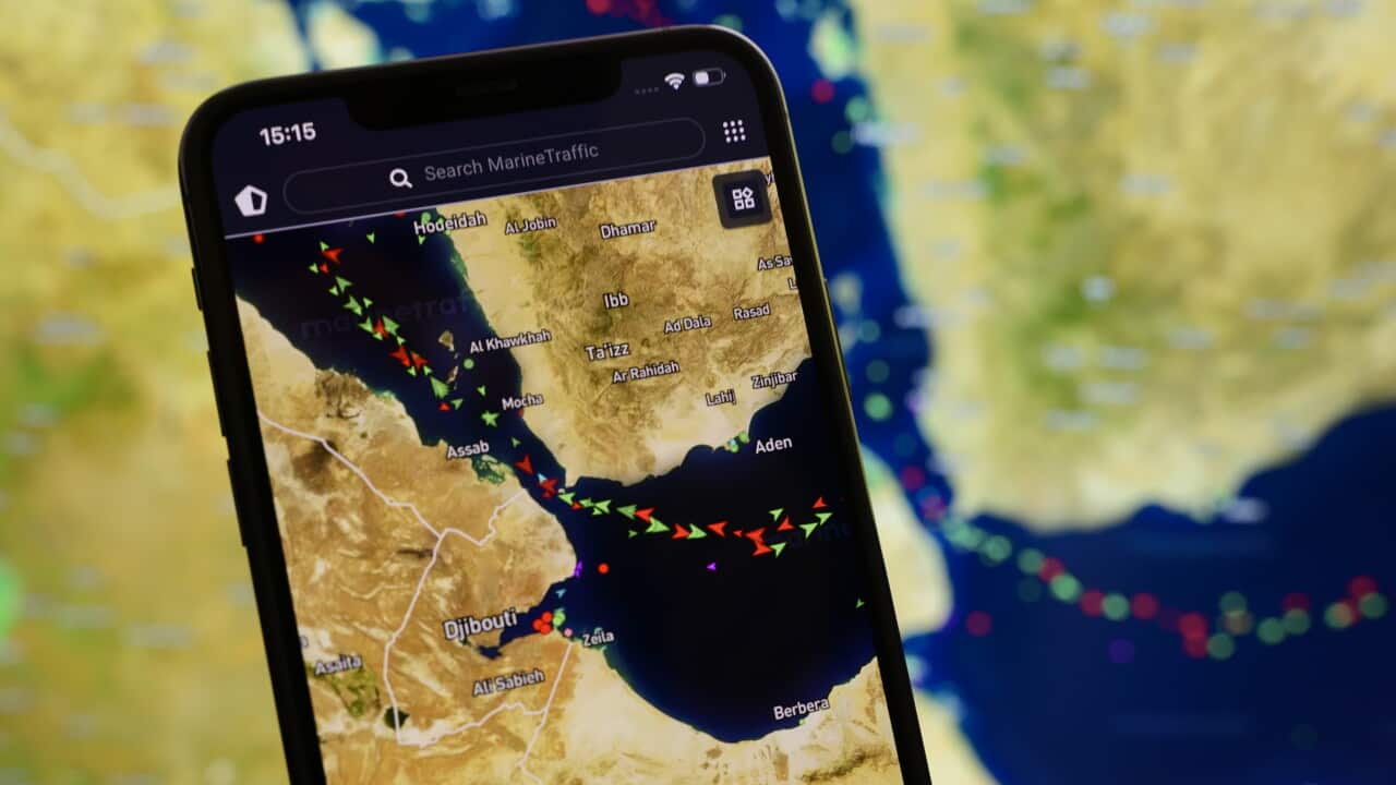 A phone showing a map of a waterway with green and red icons indicating ships moving through it.