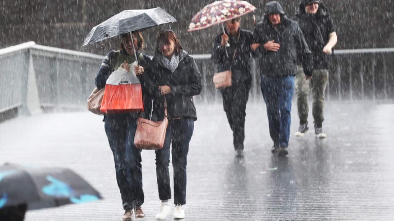 Pedestrians are seen in the rain on Southbank in Melbourne, Friday, May 10, 2019.