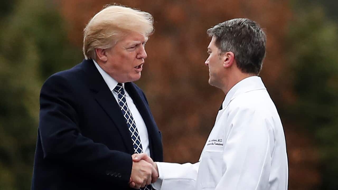 President Donald Trump shakes hands with White House physician Dr. Ronny Jackson.