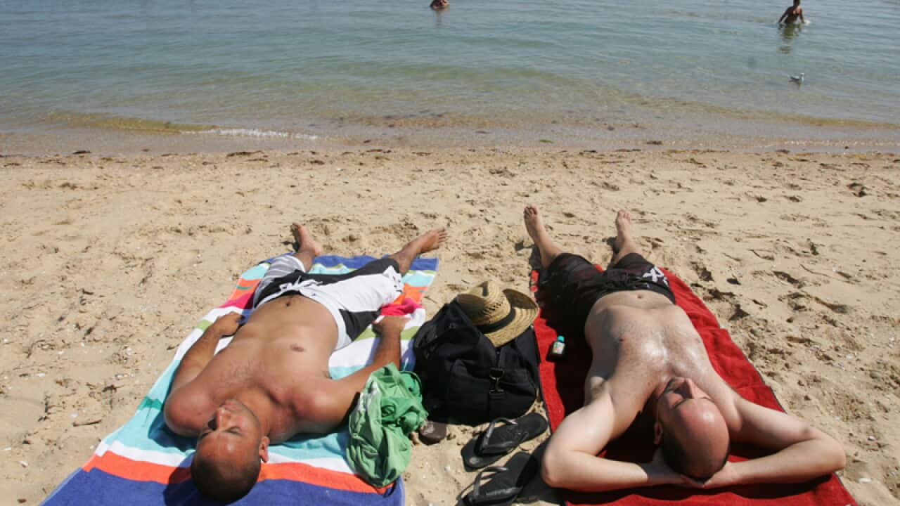 People sunbathing on a beach in Melbourne