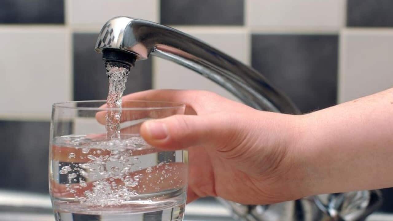Tap water being poured from a tap in to a glass.