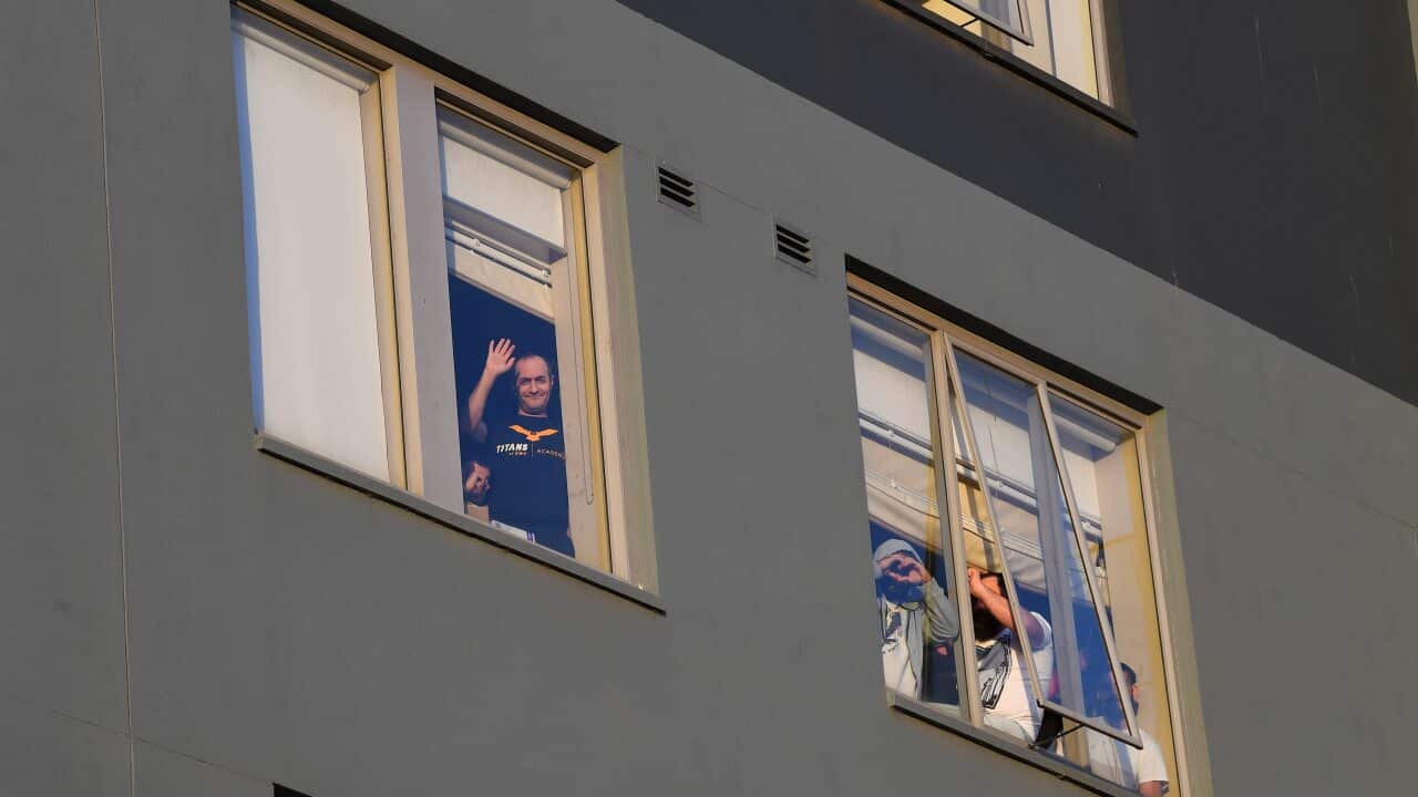 Detainees are seen through a window of the Mantra Hotel during a candlelight vigil in Preston, Melbourne, last week.