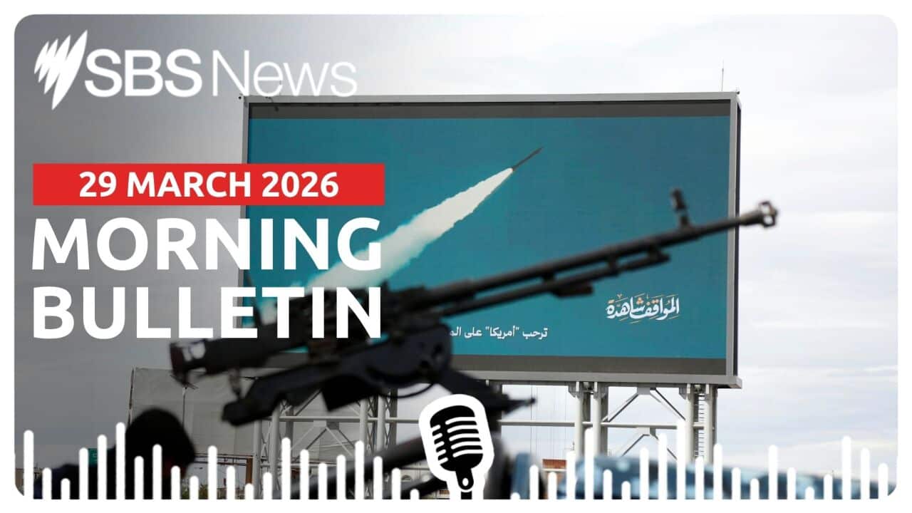 A machine gun mounted on a police vehicle next to a billboard depicting Houthi launching missile and drone attacks in Yemen.