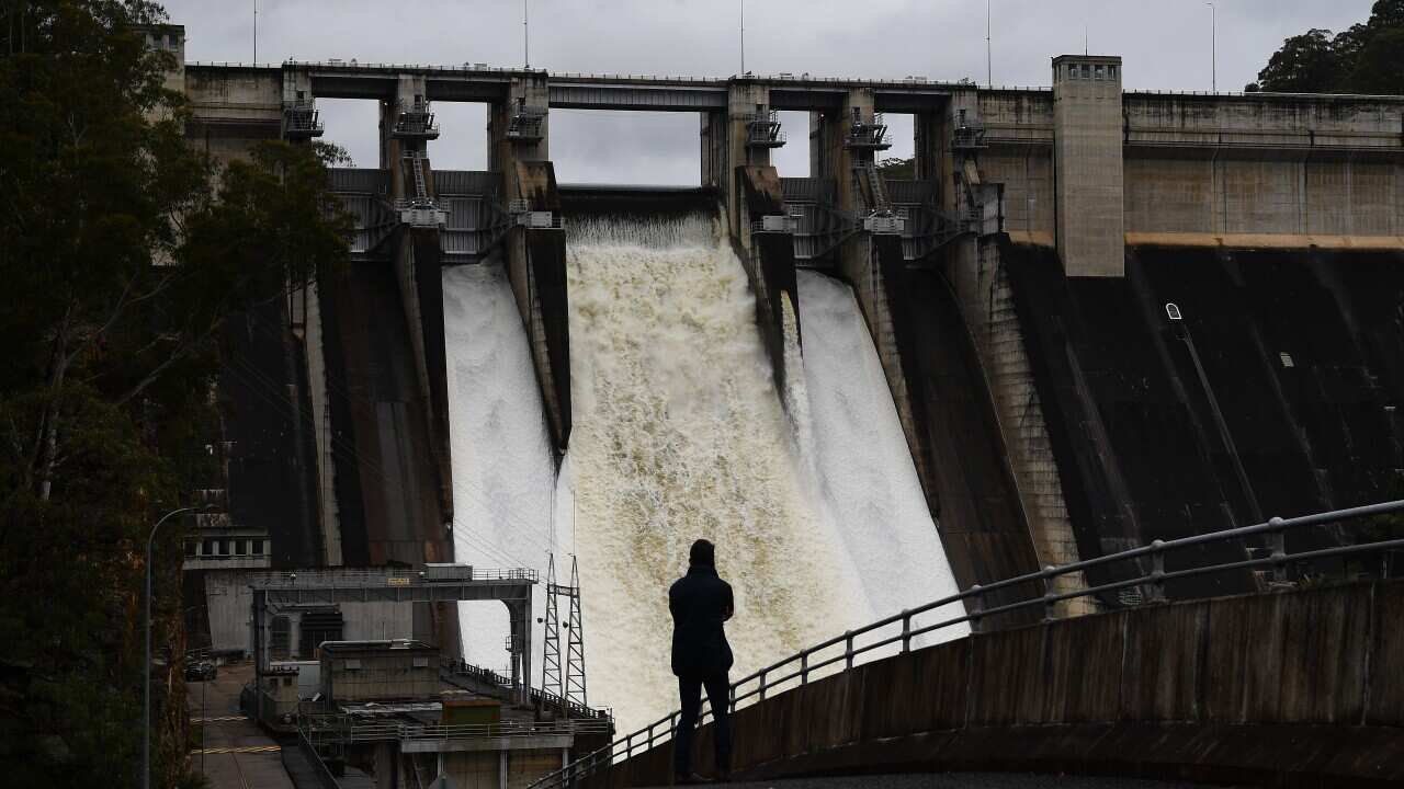 A person watches on as the Warragamba Dam spillway is seen outflowing in Warragamba, in South West Sydney, Saturday, November 27, 2021.
