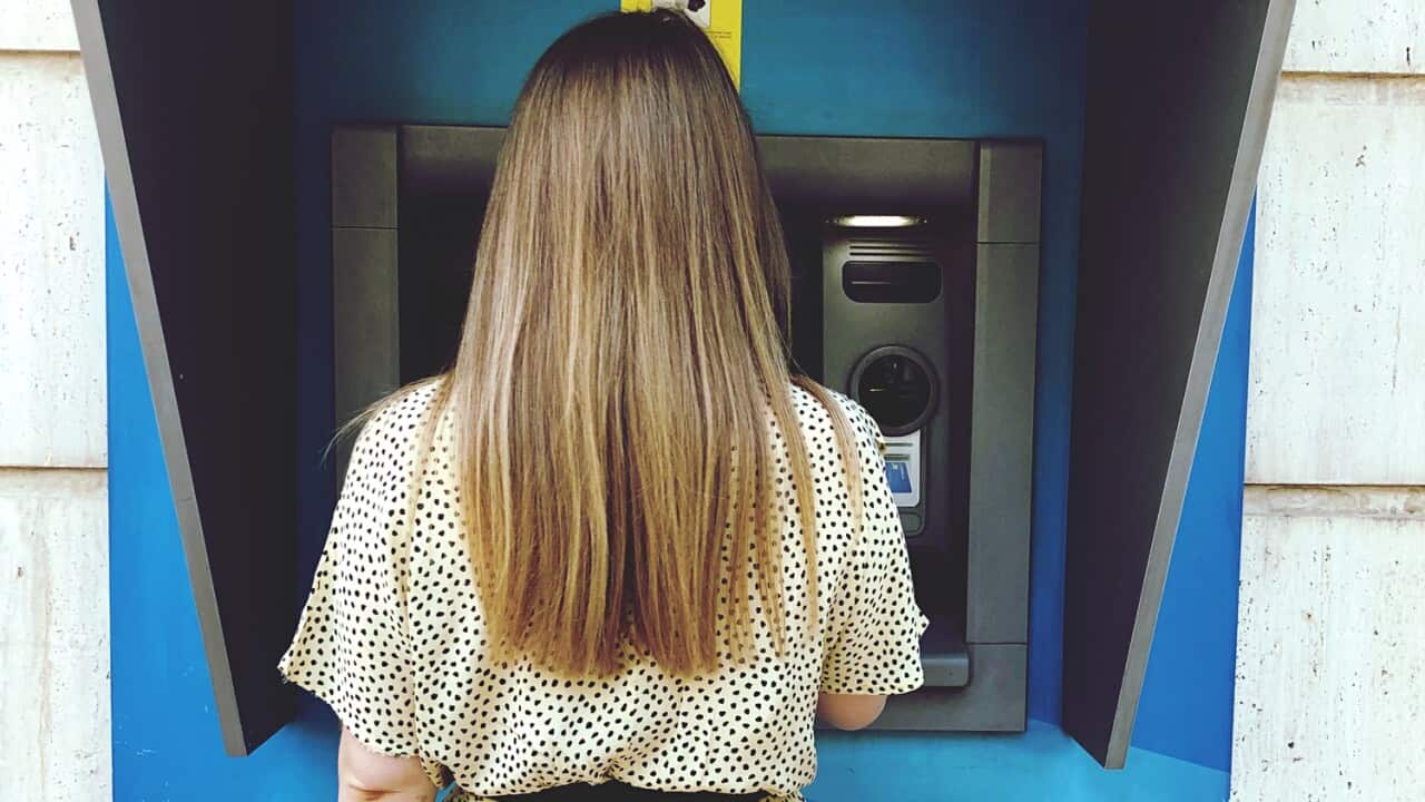 Rear View Of Woman Standing Against Atm