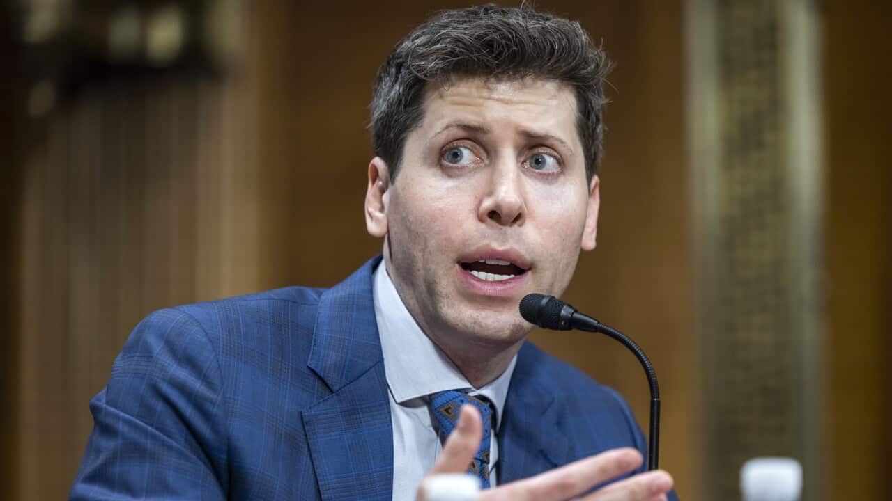 OpenAI CEO Sam Altman talking into microphone in US Senate.