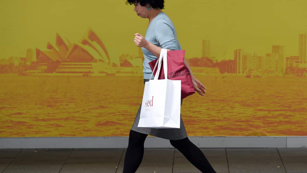 A shopper carries a bag from a retail store in Sydney