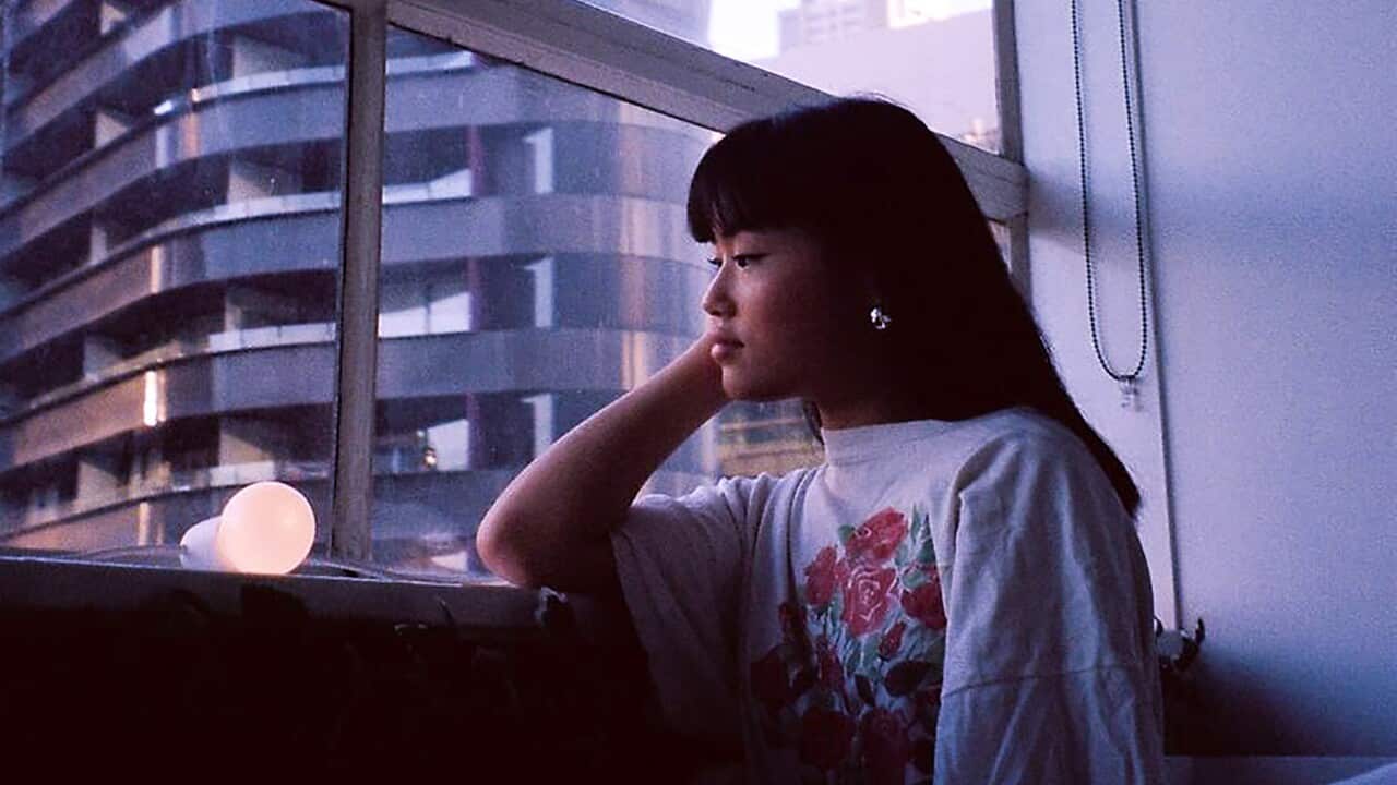 Young woman looking out of window onto the city streets