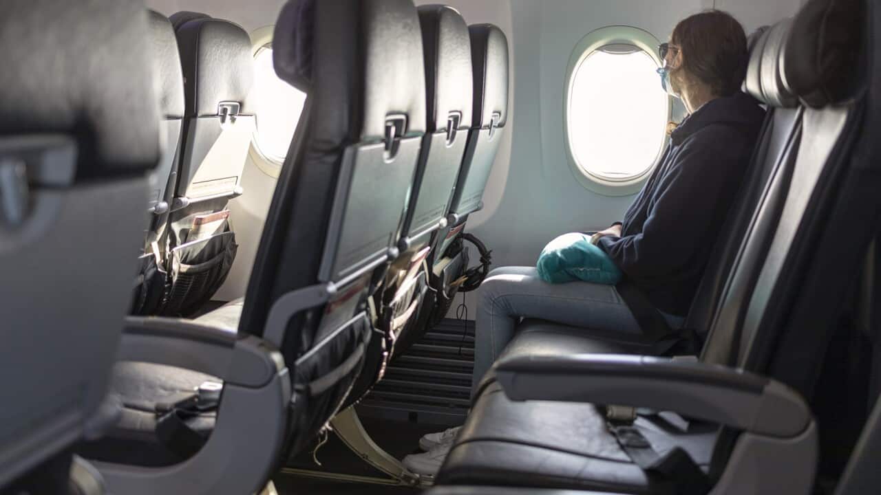 Air travel, passenger looking out airplane window, empty seats, COVID-19