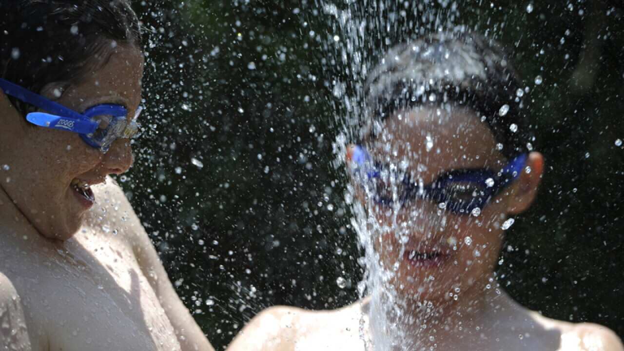 Children playing with water to cool down in Adelaide