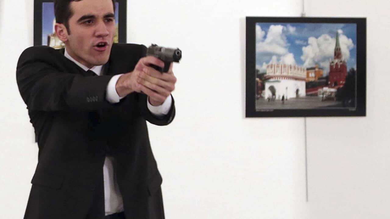 A gunman points his gun, after shooting the Russian Ambassador