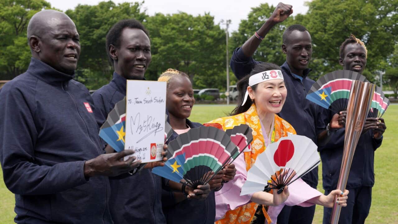 Olympic fan Kyoko Ishikawa, center, takes a photo with South Sudan athletes who have been train for the Tokyo 2020 Olympics
