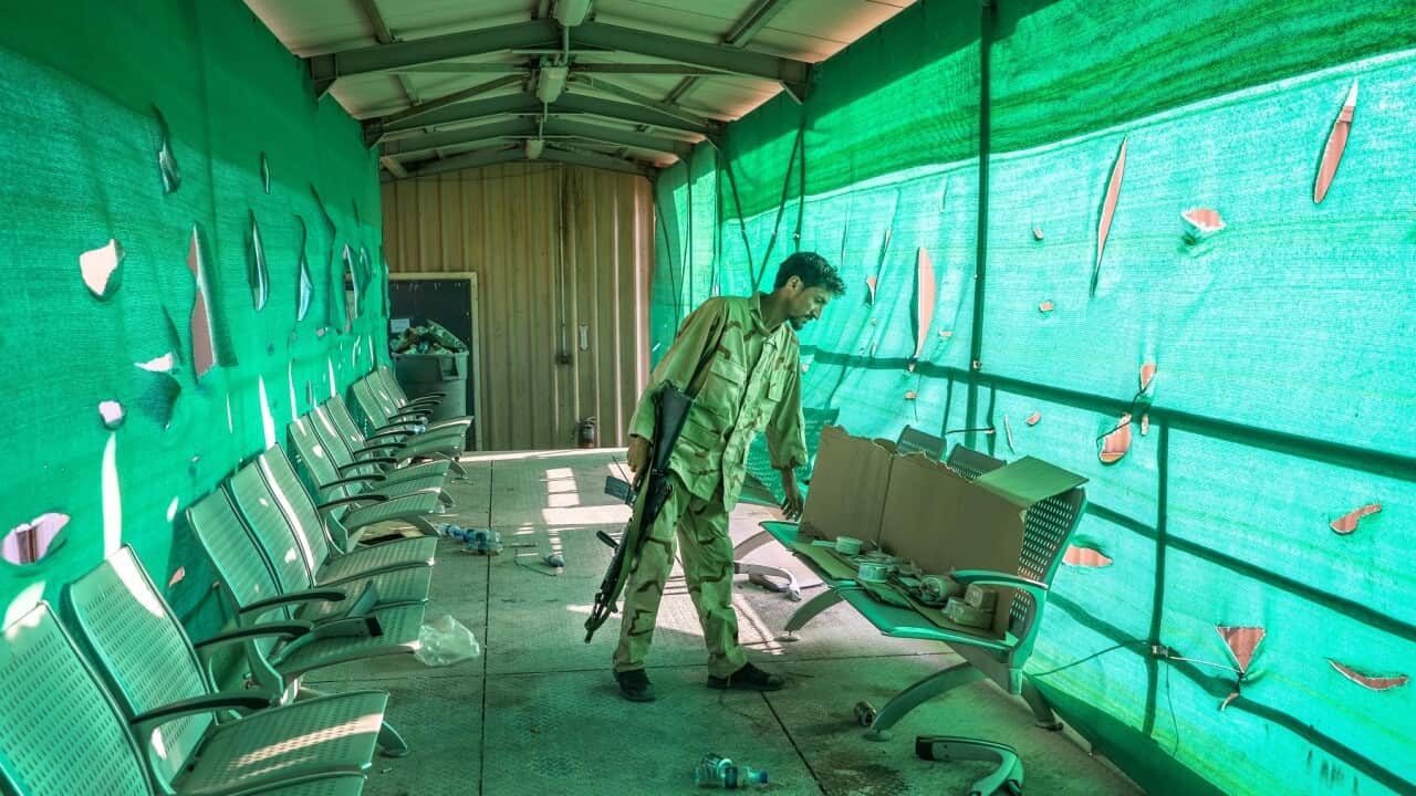 An Afghan army soldier surveys belongings left by the US military inside the Bagram Air Base