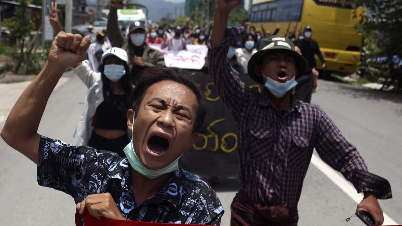 Myanmar demonstrators shout slogans as they march on a street during an anti-military coup protest in Mandalay, 13 May 2021.
