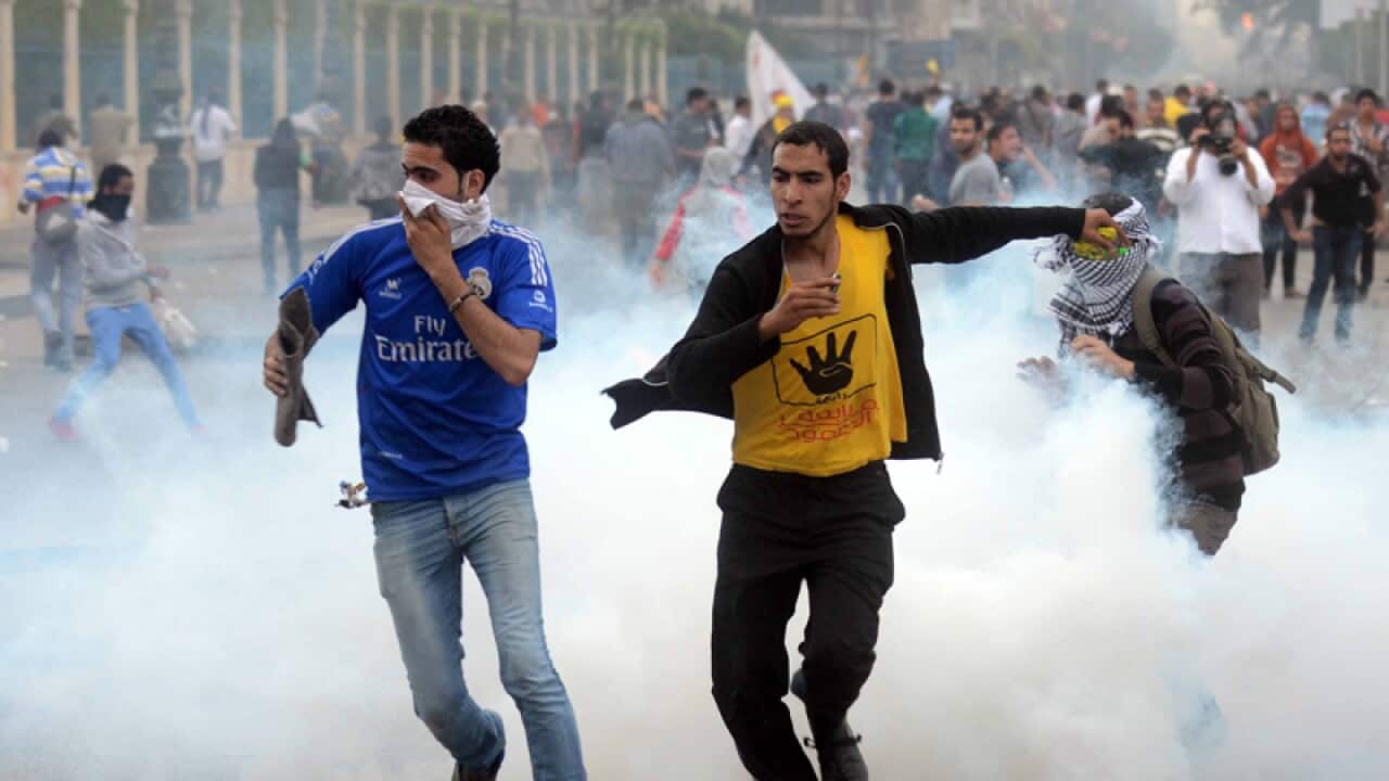 Protesters run away from tear gas.