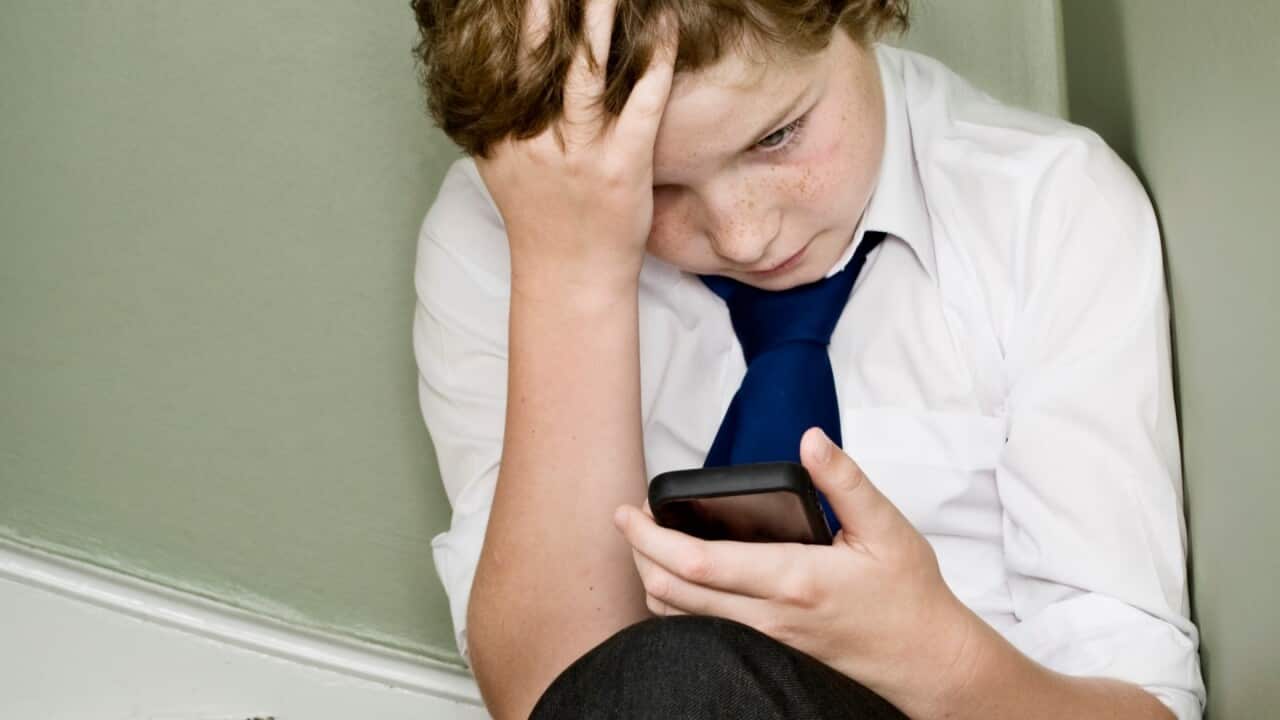 Sad boy looking at his mobile phone